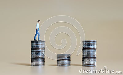 Business concept with a miniature person with a pile of coins. Stock Photo